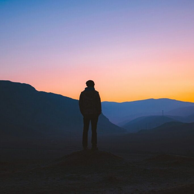 silhouette of person looking at sunrise